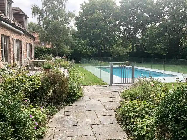 Looppad in stenen platen naar het zwembad met een lage omheining
