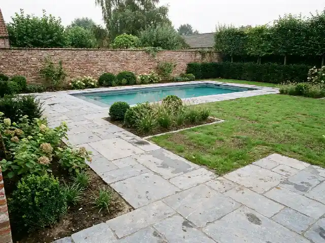 Nieuw terras in natuursteen rond een pas aangelegd zwembad