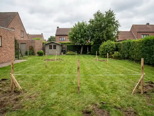 Piketten en koord die de plaats van het toekomstige zwembad afbakenen